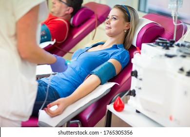 Junge Frau, die in einem modernen Krankenhaus Blut spendet (farbiges Bild)