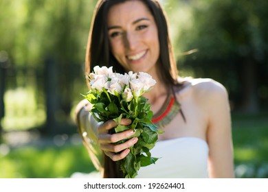 Young Woman Giving Bouquet Of Flowers