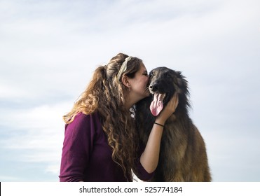 Young woman giving her dog an affectionate kiss on the face