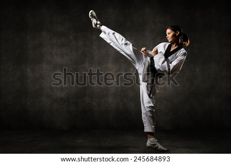Young woman giving a kick on background
