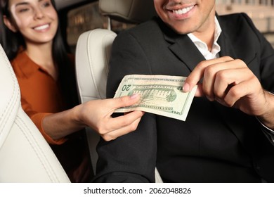 Young Woman Giving Money Taxi Driver In Modern Car, Closeup