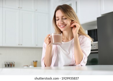 Young Woman With Glass Cup Of Chocolate Milk In Kitchen