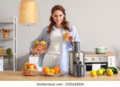 Young woman with glass of fresh fruit juice near modern juicer in kitchen - Powered by Shutterstock