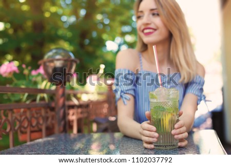 Similar – Frau mit Sonnenbrille, die im Freien grünen Gemüse-Smoothie trinkt.