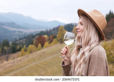 Young woman with glass of wine in peaceful mountains - Powered by Shutterstock