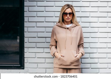Young woman in glasses and hoodie