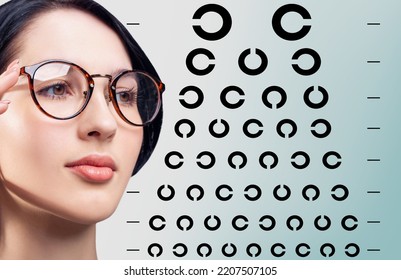 Young Woman In Glasses Near Circle Eye Chart. Ophthalmologist Consultation.