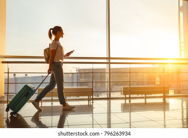 Young Woman Goes  At Airport  At Window  With A Suitcase Waiting For  Plane
