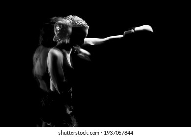 Young woman goes in for sports. She trains with boxing gloves. The photo is black and white..Movement and blow. - Powered by Shutterstock