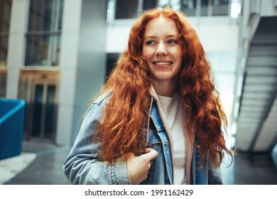 Young Woman Going To Class In College. Girl Standing In College Campus Looking Away And Smiling.