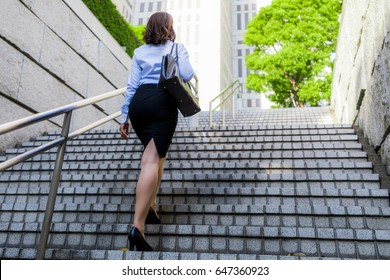 Young Woman Going Up The Stairs Back View.