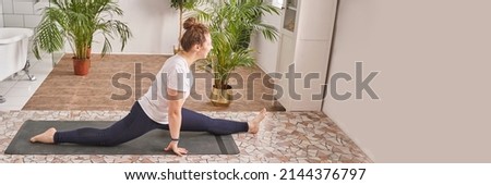 Young woman going yoga exercise at home. Health care online lessons. Indoor fitness workout. Remote sport trainer. Morning activity. Floor pilates mat. Female person lifestyle. Asana pose