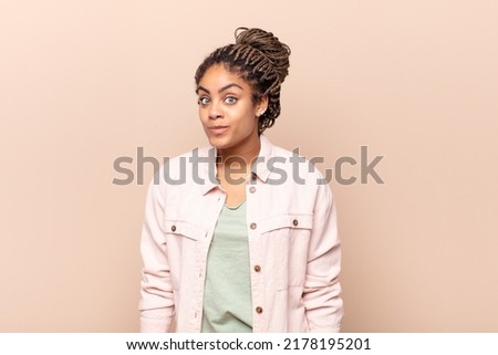 young woman with a goofy, , surprised expression, puffing cheeks, feeling stuffed, fat and full of food
