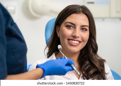 Young woman with gorgeous smile at dentist, looking at camera 
