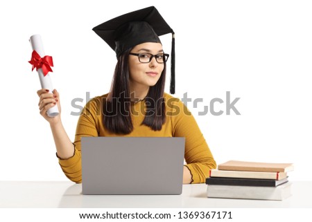 Young woman with a graduation hat and diploma sitting with a laptop and books isolated on white background