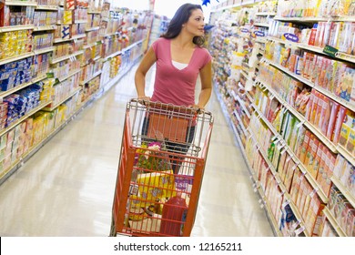 Young Woman Grocery Shopping In Supermarket