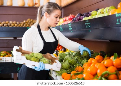 Young Woman Grocery Worker Arranging Fruits On Store Shelves