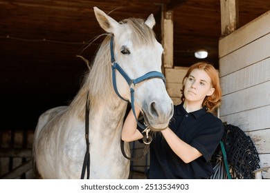 Young woman grooming white horse in stable, showing strong bond and care. Bright natural light highlighting serene stable environment - Powered by Shutterstock