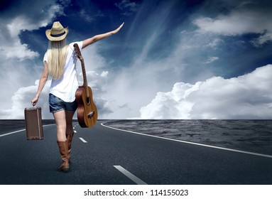 Young woman with guitar on the road and her vintage baggage - Powered by Shutterstock