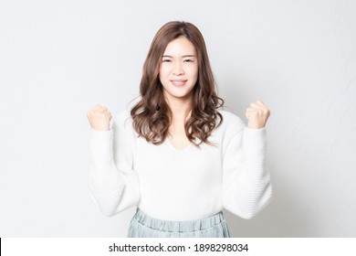 A young woman in a guts pose in front of a white wall, shot in the studio