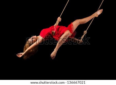 Young woman gymnast on rope on black background
