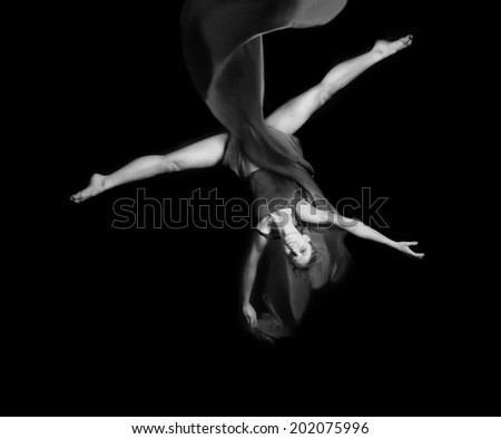 Young woman gymnaston rope on black background  