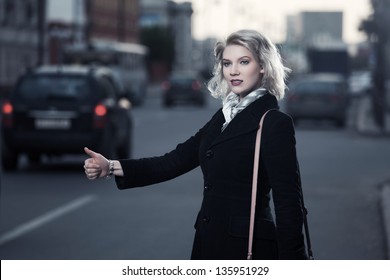 Young Woman Hailing A Taxi Cab