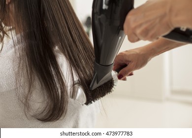 Young Woman In A Hair Salon. Drying And Shaping The Hair With A Blow Dryer And Brush