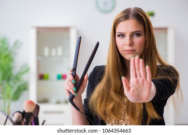 Young Woman With Hair Straightener At Home