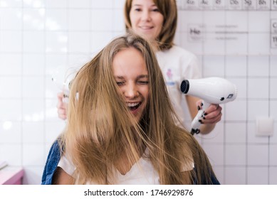 Young woman hairdresser with a hair dryer in his hands hairstyle woman beauty hair beauty salon