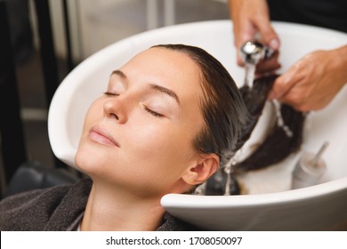 Young Woman In Hairdresser Salon During Hair Wash After Haircut