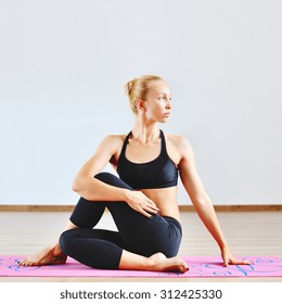 Young Woman In Half Spinal Twist Pose 