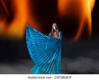 Young Woman, Half-naked Dancing With Blue Isis Wings, With A Background Of Fire