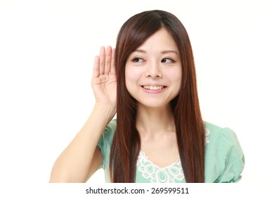 Young Woman With Hand Behind Ear Listening Closely