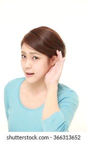 Young Woman With Hand Behind Ear Listening Closely