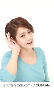 Young Woman With Hand Behind Ear Listening Closely