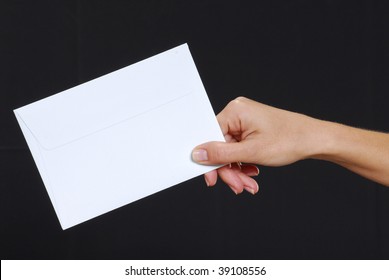 Young Woman Hand Holding An Envelope Isolated On A Black Background.