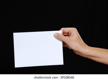 Young Woman Hand Holding An Envelope Isolated On A Black Background.