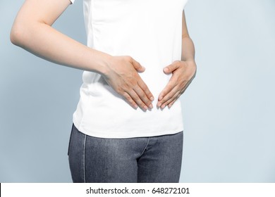 Young Woman Hand Holding Her Stomach On A White Background