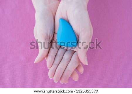 Young woman hand holding menstrual cup. Women health concept, zero waste alternatives
