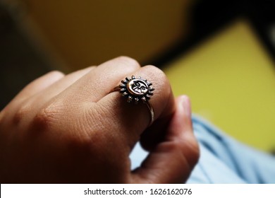 Young Woman Hand With A Ring With A Moon And A Sun With A Yellow Backround 