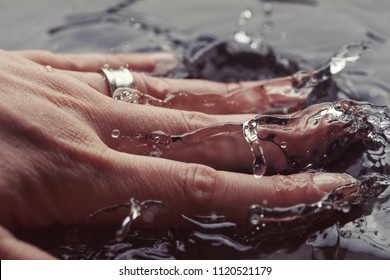 Young Woman Hand Splashing In Clean Water, Extreme Close-up Detail. Splash High-speed Photography Macro Concept Background. Female Hand With Wedding Ring Splashing Water. 