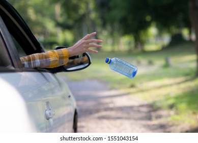 Young Woman Is Hand Throwing Plastic Bottle On The Road ,Concept Of Environmental Stewardship, Global Warming 