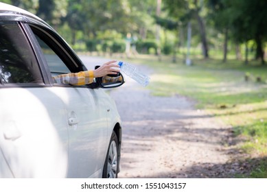 Young Woman Is Hand Throwing Plastic Bottle On The Road ,Concept Of Environmental Stewardship, Global Warming 