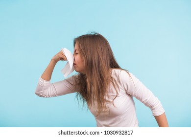 Young Woman With Handkerchief. Sick Girl Isolated Has Runny Nose On Blue Background