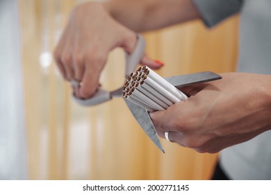 Young woman hands cut cigarettes with scissors. Quit Smok, fight nicotine addiction addicts. Close-up of scissor cutting lot of cigarette. Concept of anti-Smoking and healthy lifestyle. Copy space