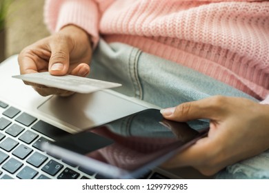 Young woman hands holding credit card and using laptop computer. Online shopping concept