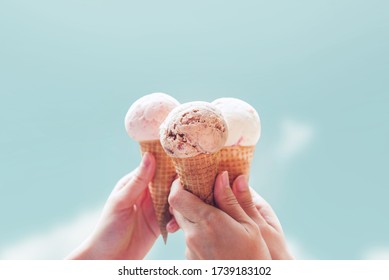 Young woman hands holding ice cream cones on sky summer background - Powered by Shutterstock