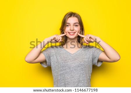 Young woman with hands on mouth with theeth smile isolated on yellow