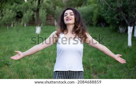 Young woman handsup  stands on nature